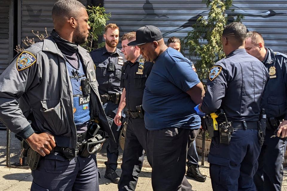 New York City Police Department officers handcuff subway shooting suspect Frank R. James in the East Village section, of New York, Wednesday, April 13, 2022 (AP)