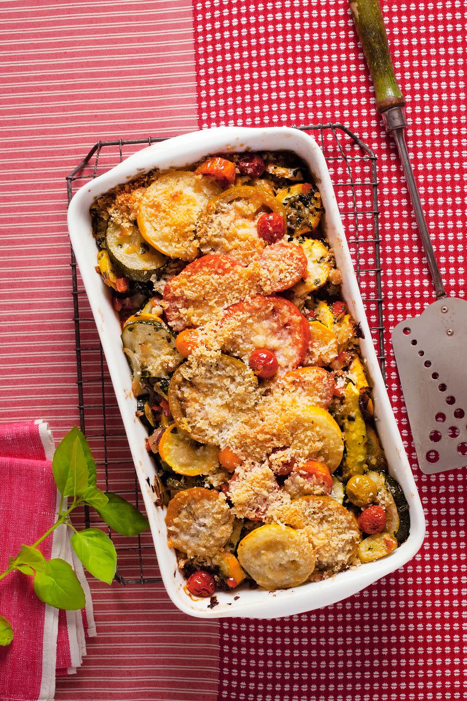 <p>Fresh summer vegetables, fragrant basil, and savory Parmesan come together beautifully in this brilliant casserole dish.</p><p><strong><a href="https://www.countryliving.com/food-drinks/recipes/a5279/golden-squash-pepper-tomato-gratin-recipe-clx0614/" rel="nofollow noopener" target="_blank" data-ylk="slk:Get the recipe" class="link ">Get the recipe</a>.</strong></p>