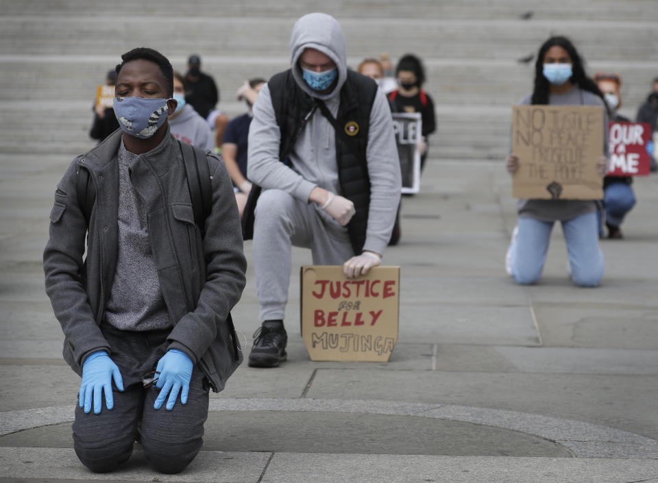 Demonstrators kneel in Trafalgar Square in London, Friday, June 5, 2020, to protest against the recent killing of George Floyd by police officers in Minneapolis, USA, that has led to protests in many countries and across the US. A US police officer has been charged with the death of George Floyd. (AP Photo/Kirsty Wigglesworth)