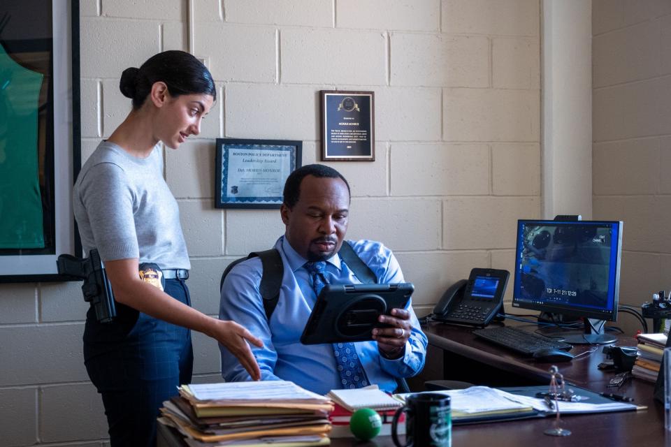 Griz (Ayden Mayeri) shows some damaging evidence against Fletch to Inspector Morris Monroe (Roy Wood Jr.) in a scene from "Confess, Fletch." The scene was filmed inside the Worcester police station.