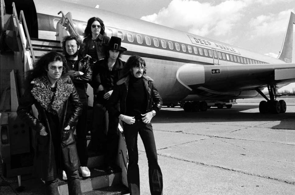 Deep Purple on the tarmac with a Deep Purple-branded jet behind them