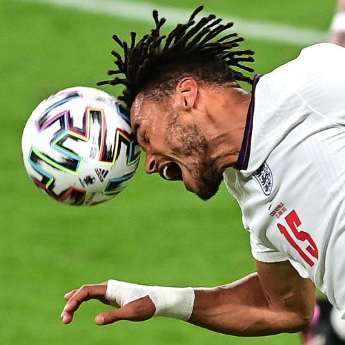 Tyrone Mings of England heads the ball.