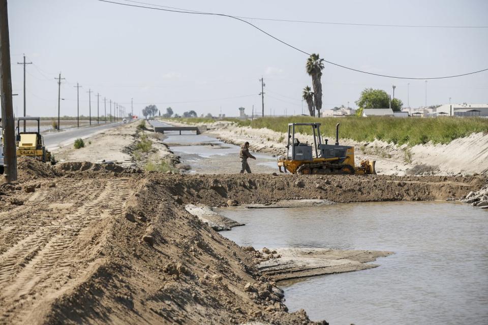 Crews repair a damaged drainage channel.