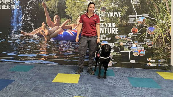 PHOTO: Detector dog Zinta is shown with her handler at Darwin airport in Darwin, Australia. (Australian Government Department of Agriculture, Fisheries and Forestry)