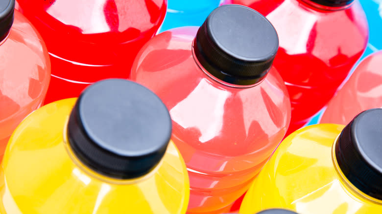 Blue, red, and yellow sports drink bottles from top