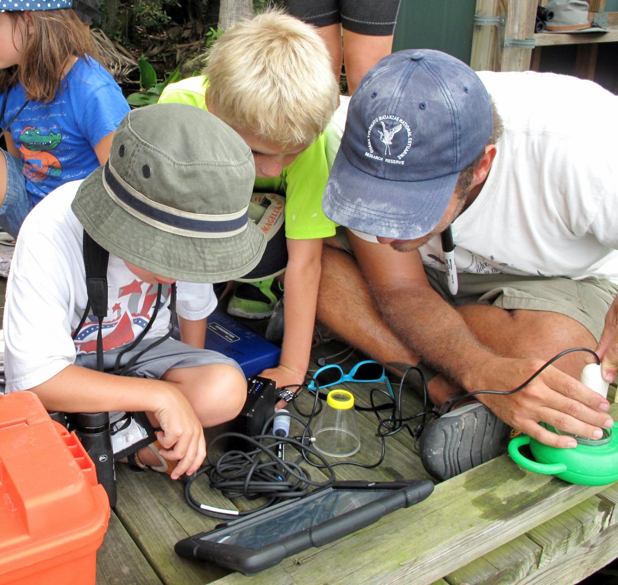 In this 2014 file photo Kenneth Rainer, education coordinator at the Guana Tolomato Matanzas National Estuarine Research Reserve, shows students how to use a smart device for a project. Technology has made a world of difference in estuarine research over the last 50 years.