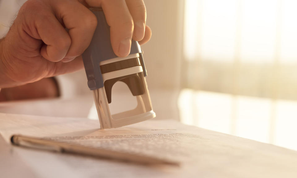 A person stamping a document.