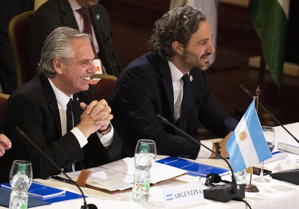 Argentina's President Alberto Fernandez, left, and his Minister of Foreign Affairs Santiago Cafiero attend the Mercosur trade bloc summit in Montevideo, Uruguay, Tuesday, Dec. 6, 2022. (AP Photo/Matilde Campodonico)