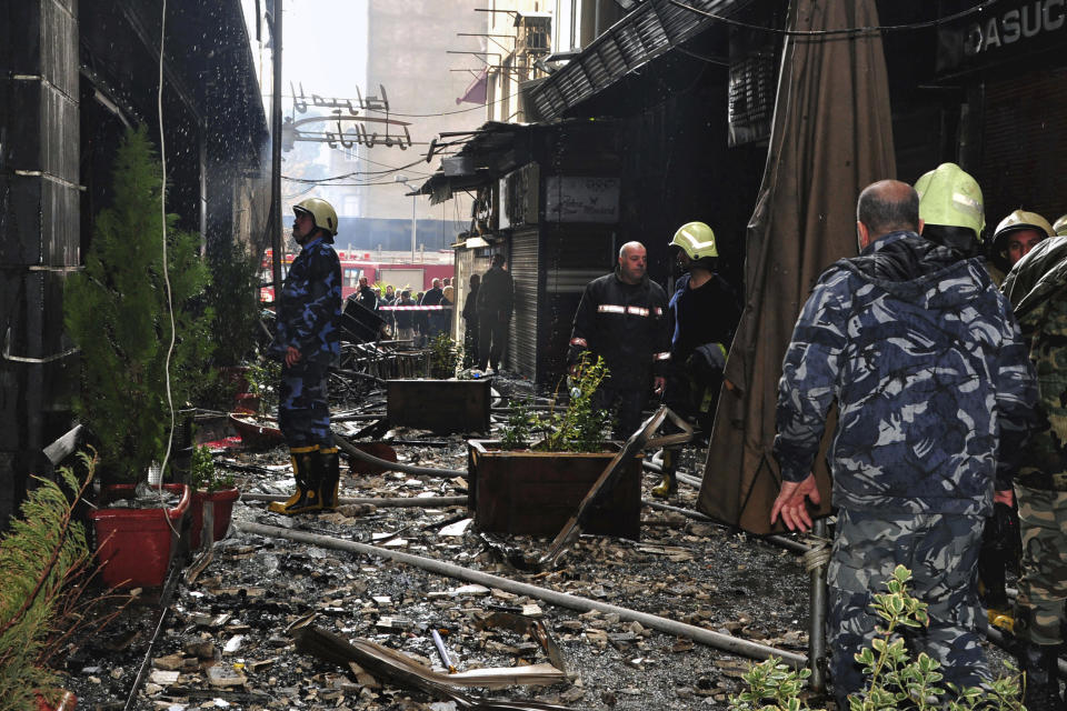 This photo released by the Syrian official news agency SANA, shows firefighters working at the scene of a fire that broke out in the La Mirada Mall building, in Damascus, Syria, Tuesday, March. 1, 2022. SANA said 11 people died and seven others were injured. (SANA via AP)