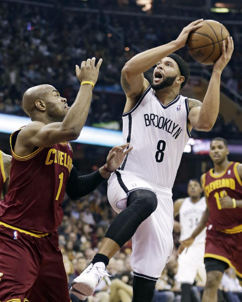 Brooklyn Nets' Deron Williams (8) tries to shoot over Cleveland Cavaliers' Jarrett Jack (1) during the first quarter of an NBA basketball game Wednesday, Oct. 30, 2013, in Cleveland. (AP Photo/Tony Dejak)