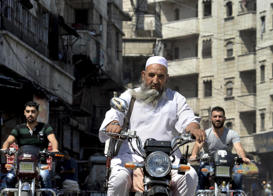 <p>In this Monday, Sept. 10, 2018 photo, an armed man rides his motorcycles in the centre of the northern city of Idlib, Syria. Syrian government forces, backed by Russia and Iran, have been massing troops for weeks in preparation for an attack on Idlib province, the last major rebel stronghold in the country. The U.N. has warned that a battle will spark a humanitarian catastrophe, where more than 3 million people live in the territory, nearly half of them already displaced from fighting elsewhere in Syria. (Ugur Can/DHA via AP) </p>