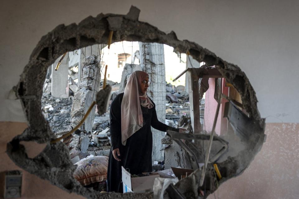 A Palestinian woman checks the rubble of a home hit by overnight Israeli bombing in Rafah (AFP via Getty Images)