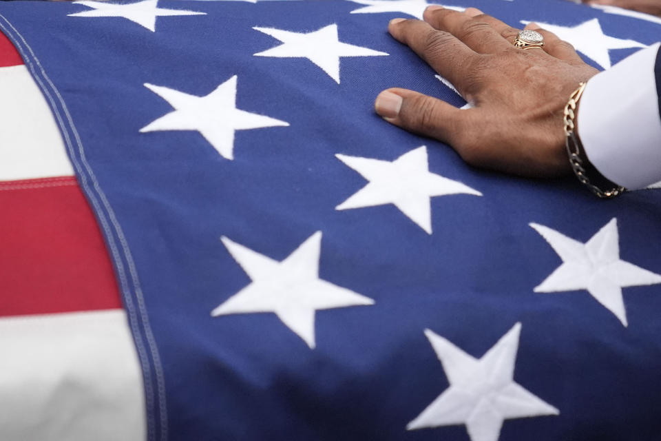 A family member touches slain airman Roger Fortson's casket, during the funeral at New Birth Missionary Baptist Church, Friday, May 17, 2024, in Stonecrest, Ga.(AP Photo/Brynn Anderson)