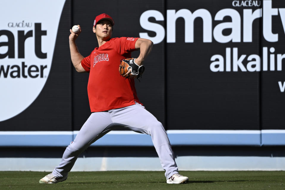 Los Angeles Angels' Shohei Ohtani warms up in the outfield prior to a preseason baseball game against the Los Angeles Dodgers Sunday, March 26, 2023, in Los Angeles. (AP Photo/Mark J. Terrill)