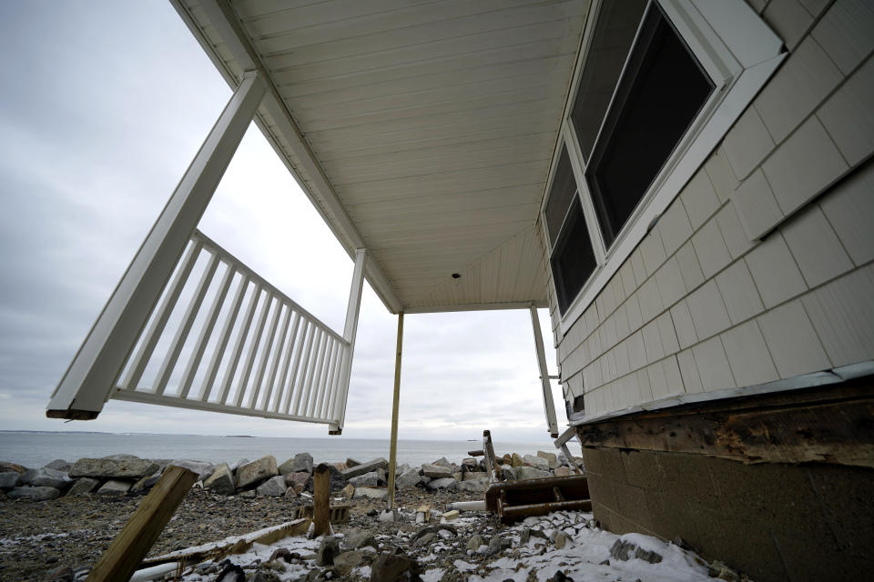 FILE -Posts and a railing are all that remain of a deck, Wednesday, Jan. 31, 2024, on a home in the Camp Ellis neighborhood of Saco, Maine. It is one of many waterfront buildings damaged by recent coastal storms. (AP Photo/Robert F. Bukaty)