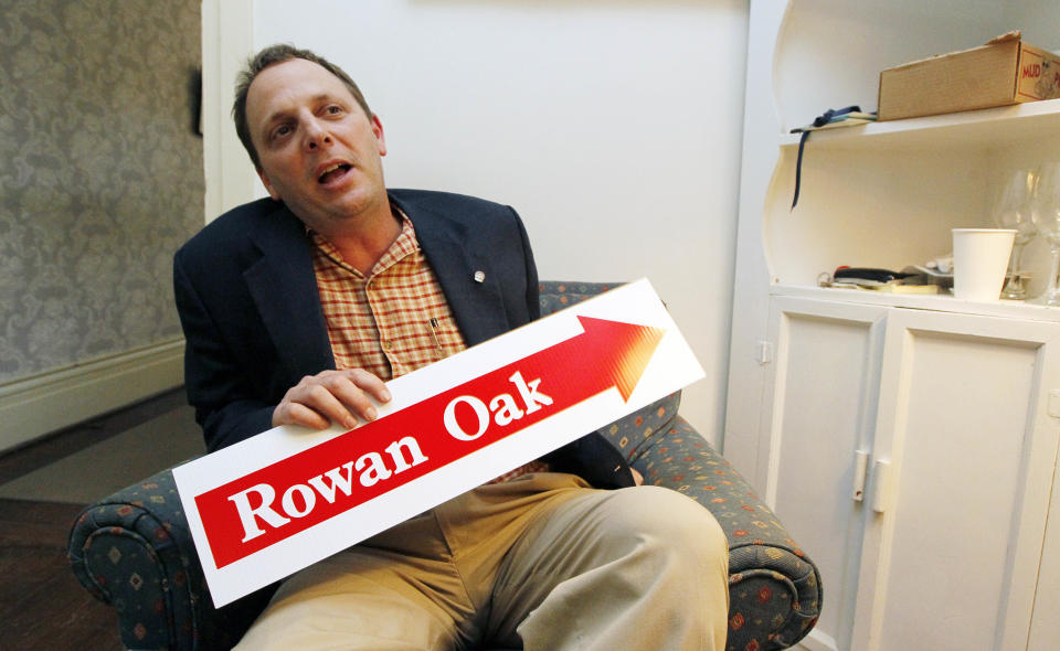 In this June 8, 2012 photograph, William Griffith, curator of Roan Oak, the home of the late Nobel Prize laureate William Faulkner, in Oxford, Miss., holds one of the signs that help directs visitors to the house from the walking trail as he discusses some of the inquiries into the writer's life. The home is maintained by the University of Mississippi as a museum and is open to visitors year round. (AP Photo/Rogelio V. Solis)