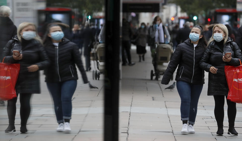 Shoppers walk along Oxford Street in London, Tuesday, Oct. 13, 2020. Unemployment across the U.K. rose sharply in August which is a clear indication that the jobless rate is set to spike higher when a government salary-support scheme ends this month and new restrictions are imposed on local areas to suppress a resurgence of the coronavirus. (AP Photo/Frank Augstein)