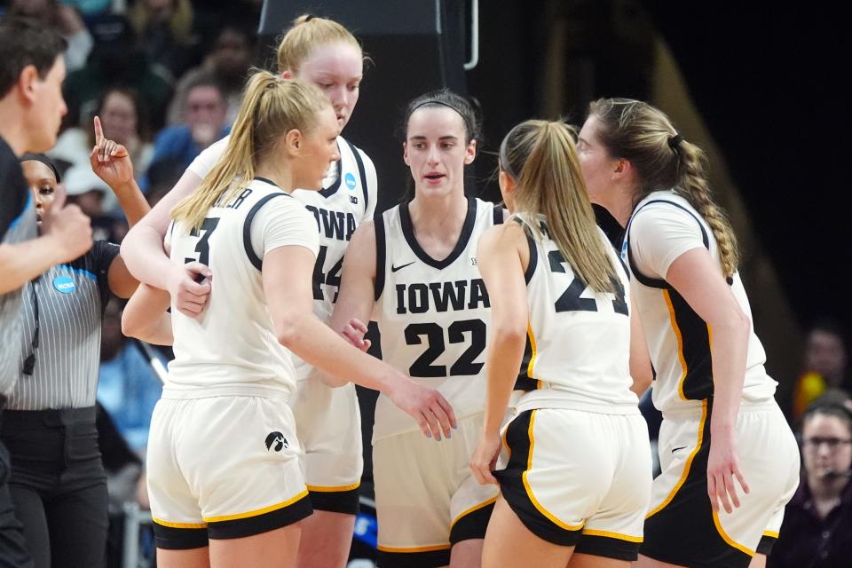Iowa's Caitlin Clark (22) talks with teammates in a huddle in the fourth quarter against LSU in the final of the Albany Regional on Monday.