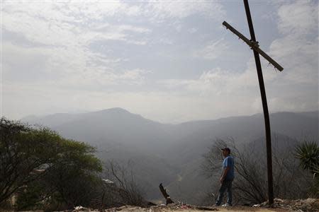 Auto mechanic Juan Freire looks at a valley, where a housing development was meant to be built, at El Chaparral commune in La Guaira May 2, 2014. REUTERS/Carlos Garcia Rawlins