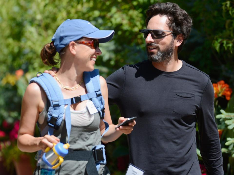 Anne Wojcicki smiles at Sergey Brin while walking outside