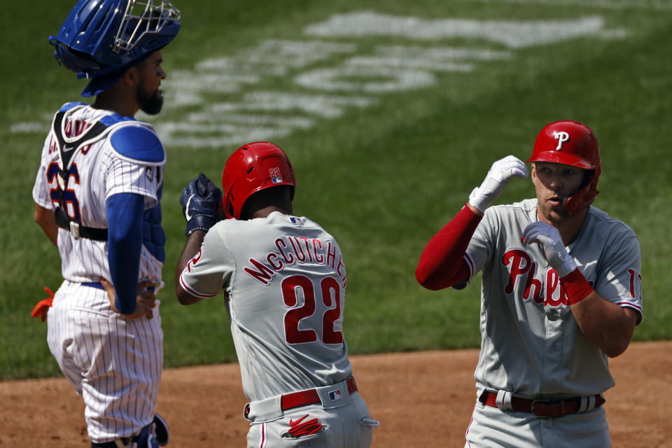 Philadelphia Phillies' Rhys Hoskins celebrates a two-run home run with Andrew McCutchen (22) in front of New York Mets catcher Robinson Chirinos during the second inning of a baseball game on Monday, Sept. 7, 2020, in New York. (AP Photo/Adam Hunger)