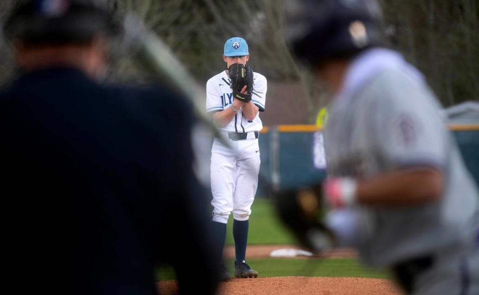 Olympia starting pitcher Lincoln Berg squares off against Puyallup’s Donte Grant to open Wednesday afternoon’s baseball game at Olympia High School in Olympia, Washington, on April 12, 2023. Puyallup won the game, 6-2.