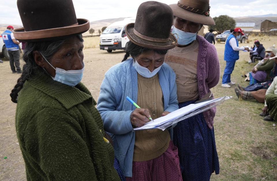 Women sign up to get a dose of the Sinopharm vaccine for COVID-19 during a vaccine campaign in Mijane, Peru, Thursday, Oct. 28, 2021. While more than 55% of Peruvians have gotten at least one shot of COVID-19 vaccines, only about 25% of people in Indigenous areas have been vaccinated. (AP Photo/Martin Mejia)