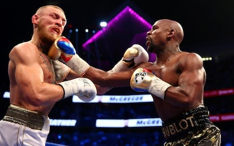 Floyd Mayweather Jr. lands a hit against Conor McGregor during a boxing match at T-Mobile Arena - Credit: USA TODAY SPORTS