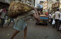 <p>An Indian laborer carries vegetables in a basket on his back at a vegetable market in Gauhati, India, Sunday, May 21, 2017. (Photo: Anupam Nath/AP) </p>