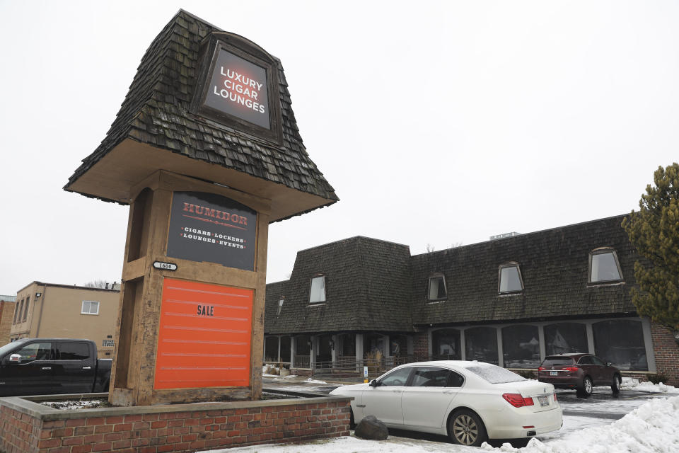 A car is parked by the sign of a Humidor cigar lounge in Lisle, Ill., on Saturday, Jan. 25, 2020. A woman fatally shot a retired Illinois State Police trooper and wounded another retired state trooper and an off-duty trooper before turning the gun on herself at the cigar lounge Friday night, in the Chicago suburbs, police said. (Abel Uribe/Chicago Tribune via AP)