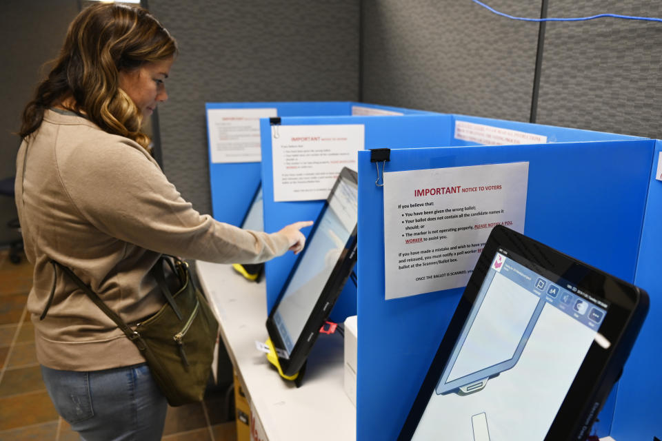 Courtney Parker votes on a new voting machine, Tuesday, Nov. 5, 2019, in Dallas, Ga. New voting machines that combine touchscreens with paper ballots are getting a limited test run in Georgia, as officials rush to meet a court-ordered deadline to retire the old system before any votes are cast in 2020. (AP Photo/Mike Stewart)