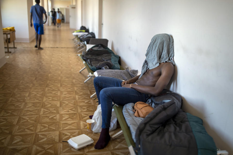 A migrant from Cameroon rests at the refugee camp in the village of Vydeniai, Lithuania, Saturday, July 10, 2021. European Union member Lithuania has declared a state of emergency due to an influx of migrants from neighboring Belarus in the last few days. Lithuania's interior minister said late Friday that the decision, proposed by the State Border Guard Service, was necessary not because of increased threats to the country of 2.8 million but to put a more robust system in place to handle migrants. (AP Photo/Mindaugas Kulbis)