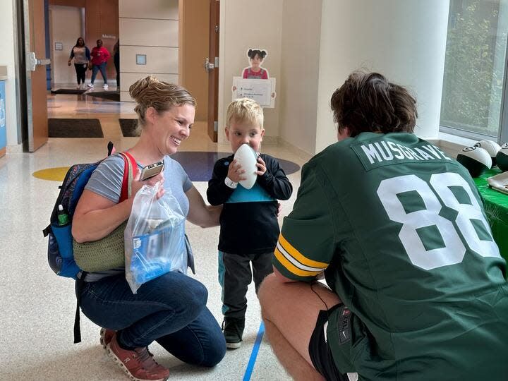 Green Bay Packers tight end Luke Musgrave chats with a young boy and his mother at Children's Wisconsin Milwaukee Hospital on Tuesday.