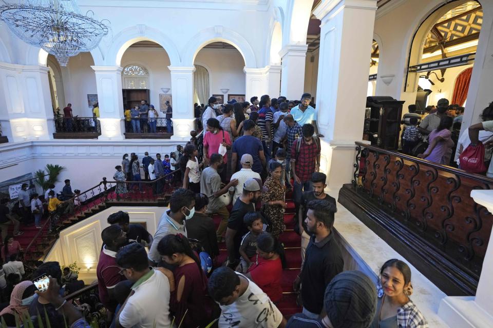 Protesters look around at the president's official residence a day after it was stormed in Colombo, Sri Lanka, Sunday, July 10, 2022. Sri Lanka’s opposition political parties will meet Sunday to agree on a new government a day after the country’s president and prime minister offered to resign in the country’s most chaotic day in months of political turmoil, with protesters storming both officials’ homes and setting fire to one of the buildings in a rage over the nation’s economic crisis. (AP Photo/Eranga Jayawardena)