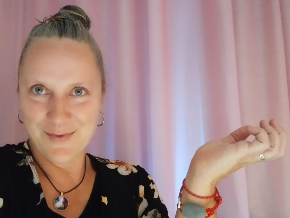 A woman showing her red bracelet.