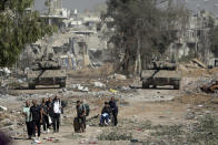 FILE - Palestinians flee from northern Gaza as Israeli tanks block the Salah al-Din road in the central Gaza Strip Friday, Nov. 24, 2023, as the four-day cease-fire in the Israel-Hamas war begins as part of an agreement that Qatar helped broker. The New York Times has frequently been at the forefront with journalists questioning their organization, including a debate surrounding another contentious issue, the war in Gaza. (AP Photo/Mohammed Dahman, File)