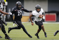 Army quarterback Christian Anderson, right, cuts up field past Cincinnati linebacker Darrian Beavers during the first half of an NCAA college football game Saturday, Sept. 26, 2020, in Cincinnati, Ohio. (AP Photo/Jay LaPrete)