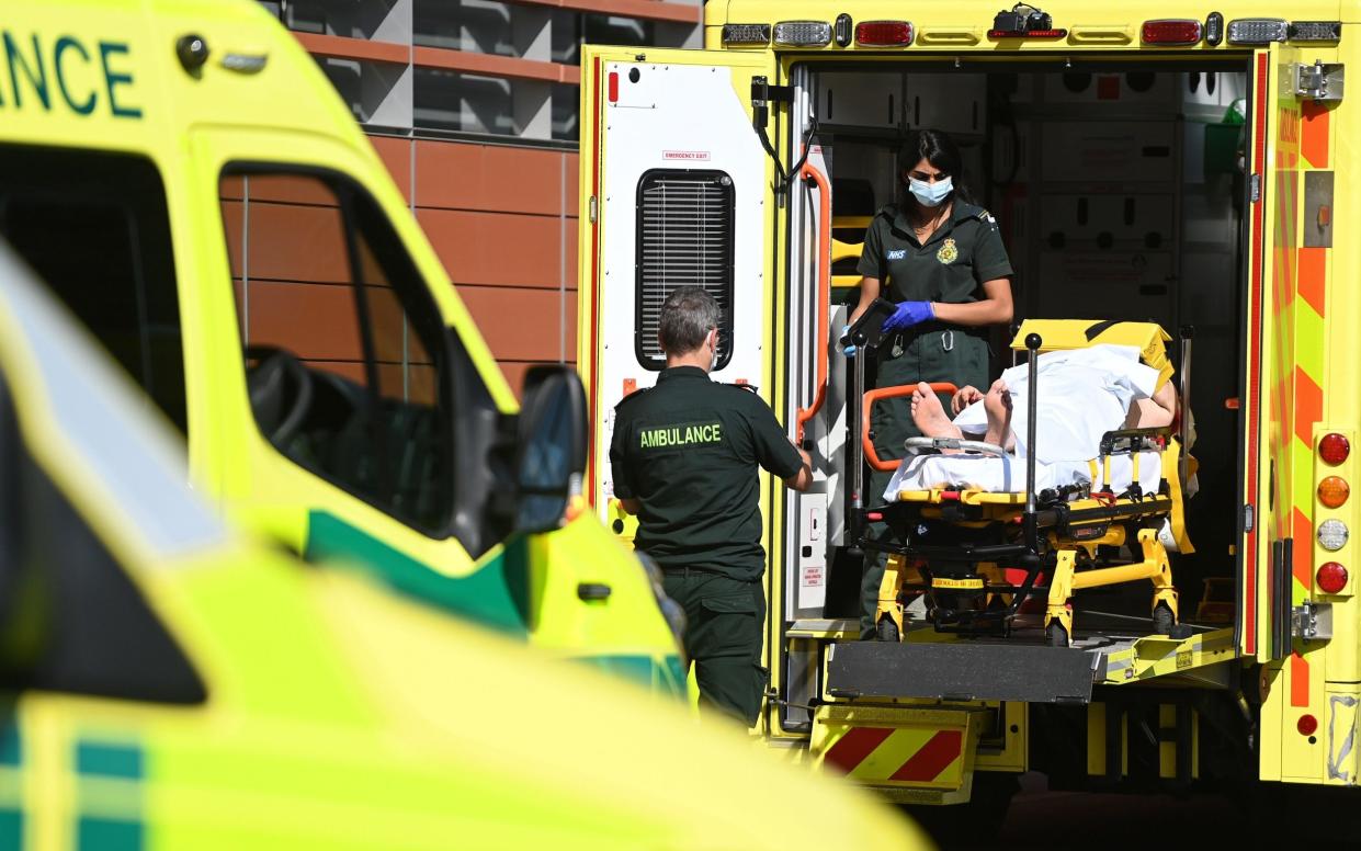 NHS Ambulance staff outside a hospital in London - Andy Rain/Shutterstock