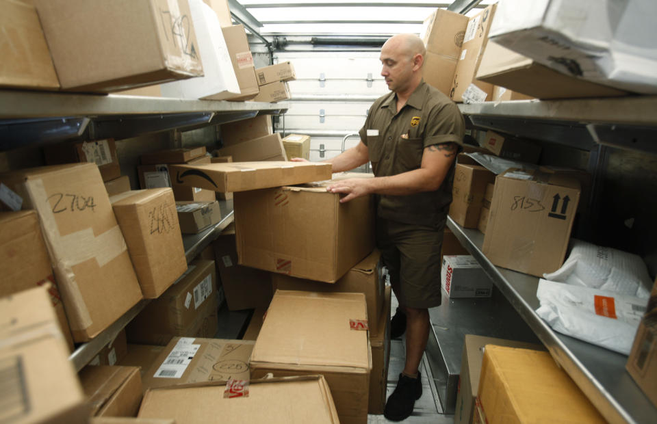 In this Oct. 18, 2010 photo, United Parcel Service (UPS) driver Paul Musial sorts packages in his truck in Palo Alto, Calif. UPS is increasing its earnings forecast for the year after reporting its third-quarter earnings jumped 81 percent Thursday, Oct. 21, 2010. (AP Photo/Paul Sakuma)