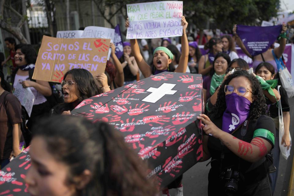 Mujeres cargan un ataúd simulado cubierto con los nombres de víctimas de violencia de género durante una marcha para conmemorar el Día Internacional de la Eliminación de la Violencia contra la Mujer, en Lima, Perú, el sábado 25 de noviembre de 2023. (Foto AP/Martín Mejía)