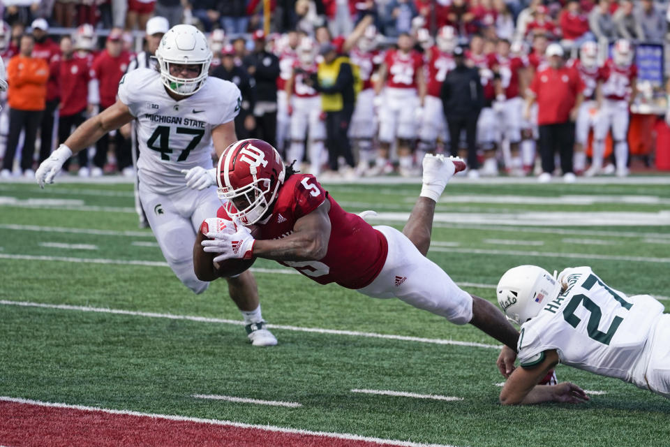 Indiana's Stephen Carr (5) dives in for a touchdown while being tackled by Michigan State's Cal Haladay (27) during the second half of an NCAA college football game, Saturday, Oct. 16, 2021, in Bloomington, Ind. Michigan State won 20-15. (AP Photo/Darron Cummings)