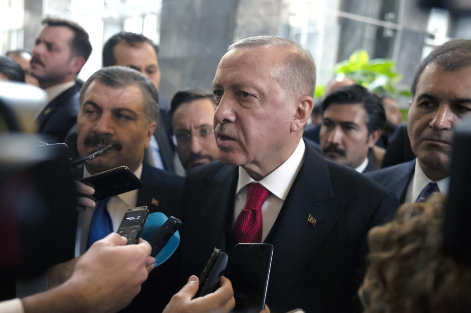 Turkish President Recep Tayyip Erdogan speaks to journalists at the parliament, in Ankara, Turkey, Wednesday, Feb. 12, 2020. Erdogan said Wednesday that Turkey will attack government forces anywhere in Syria if another Turkish soldier is injured.(AP Photo/Burhan Ozbilici)