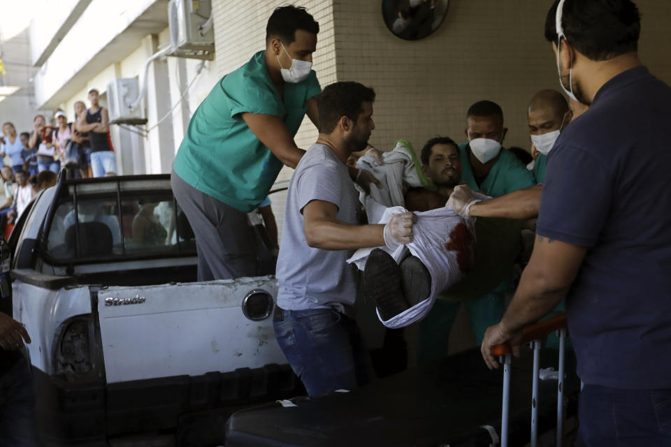 An injured person is lifted to a stretcher outside the Getulio Vargas Hospital after a police raid on the Vila Cruzeiro favela in Rio de Janeiro, Brazil, Tuesday, May 24, 2022. Police raided the favela before dawn Tuesday in an operation that prompted a fierce firefight and state officials said at least 11 people died. (AP Photo/Bruna Prado)