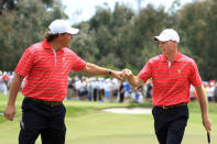 MELBOURNE, AUSTRALIA - NOVEMBER 18: (L-R) Phil Mickelson of the U.S. Team and teammate Jim Furyk show camaraderie on the tenth green during the Day Two Four-Ball Matches of the 2011 Presidents Cup at Royal Melbourne Golf Course on November 18, 2011 in Melbourne, Australia. (Photo by Scott Halleran/Getty Images)