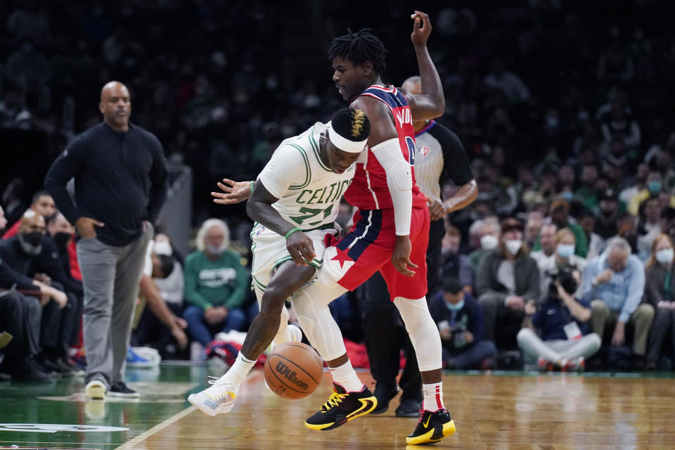 Washington Wizards guard Aaron Holiday, right, fouls Boston Celtics guard Dennis Schroder (71) during the first half of an NBA basketball game, Wednesday, Oct. 27, 2021, in Boston. (AP Photo/Charles Krupa)