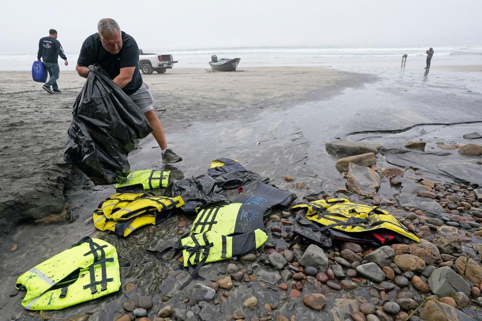 Boat salvager Robert Butler, front, picks up life preservers in front of one of two boats sitting on Blacks Beach, in San Diego. Authorities say multiple people were killed when two suspected smuggling boats overturned off the coast San Diego, and crews were searching for additional victims California Boat Deaths, San Diego, United States - 12 Mar 2023