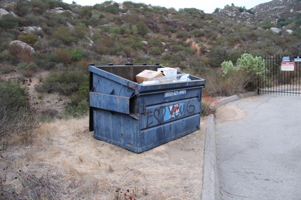 On a barren mountainside in rural San Diego County, investigators came upon this dumpster. Among the items they found inside of it: bags of  Q.C.'s belongings, $10,000 in cash and her body wrapped in a green blanket / Credit: Newport Beach Police Dept.