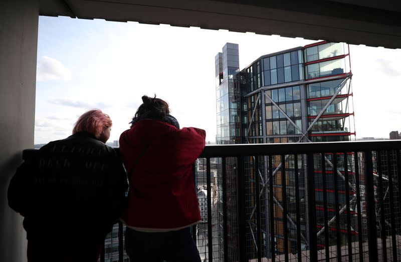 Visitors look out from the Viewing Level towards a luxury block of flats from the Tate Modern gallery in London