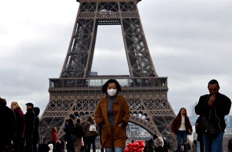 A woman wears a protective mask in light of the coronavirus outbreak in China as she walks at the Trocadero esplanade in front of the Eiffel Tower in Paris