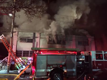 Smoke pours from a warehouse, which caught fire during a dance party in Oakland, California, U.S. December 3, 2016. Seung Lee/Handout via Reuters